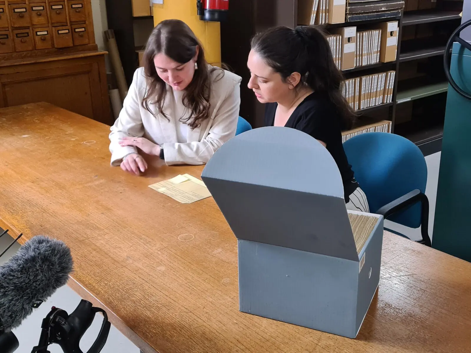 Twee collega's van het CBG doen onderzoek aan een tafel in het archief